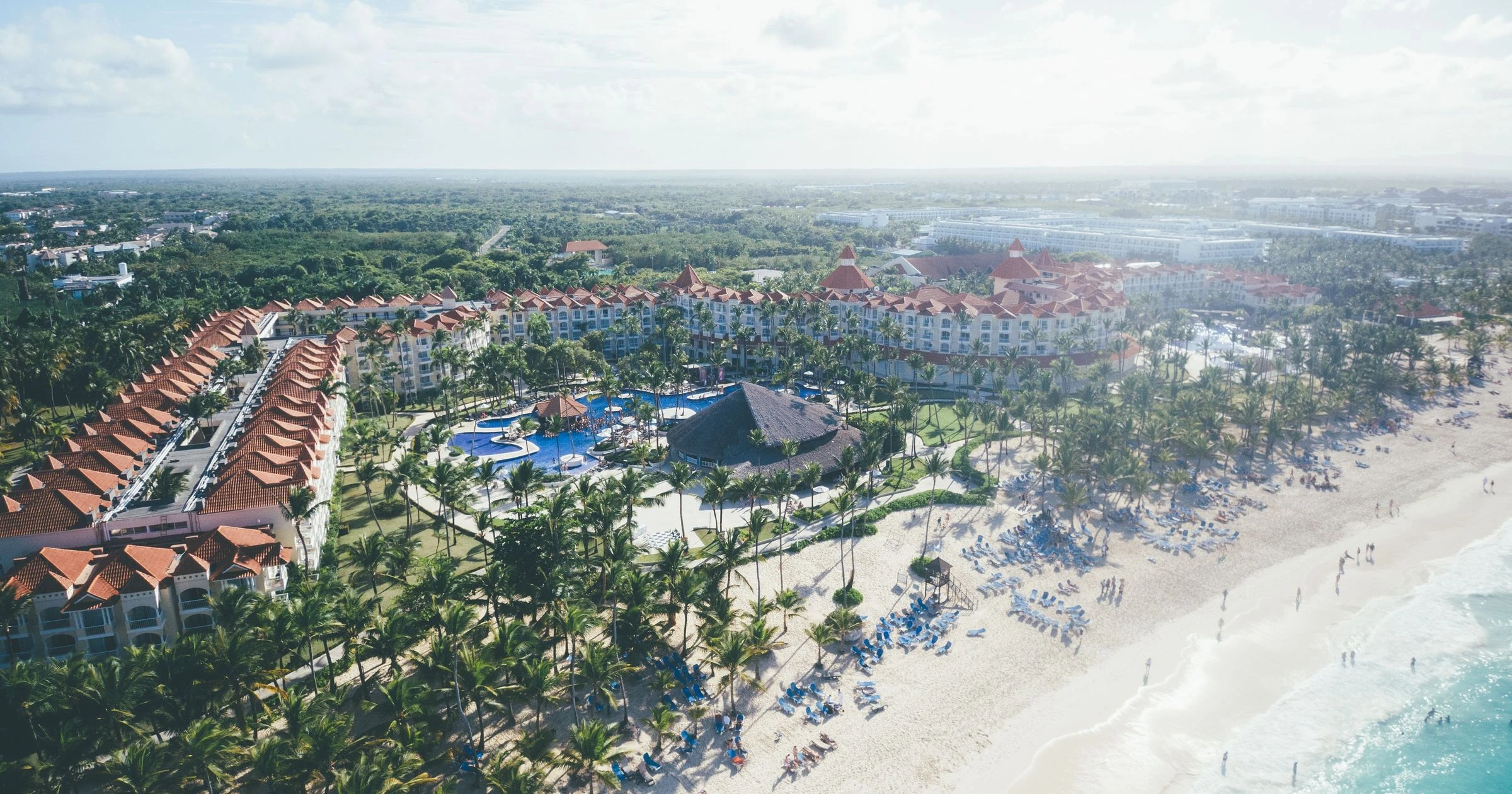 Aerial shot of a tropical beach resort in Punta Cana with palm trees and ocean views.