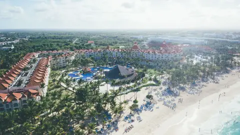 Aerial shot of a tropical beach resort in Punta Cana with palm trees and ocean views.